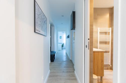 einen Flur mit weißen Wänden und Holzböden in der Unterkunft T3 avec Terrasse & Jardin Proche de la gare Alfred Musset in Clermont-Ferrand