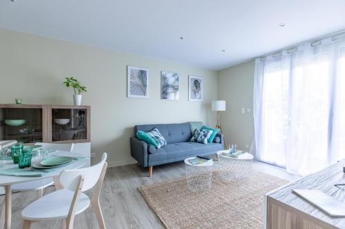 un salon avec un canapé bleu et une table dans l'établissement T3 avec Terrasse & Jardin Proche de la gare Alfred Musset, à Clermont-Ferrand