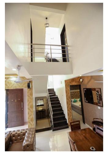 a living room with a staircase and a couch at Sunflower Villa in Lonavala