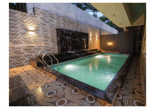 a swimming pool with a fireplace in a house at Sunflower Villa in Lonavala