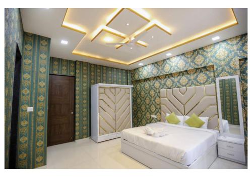 a bedroom with a white bed and a ceiling at Sunflower Villa in Lonavala