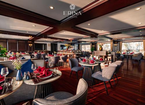 een restaurant met tafels en stoelen en een bar bij Erina Cruise in Ha Long