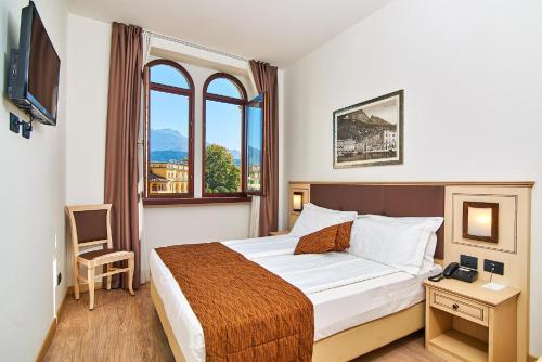 a hotel room with a bed and a window at Hotel Europa - Skypool & Panorama in Riva del Garda
