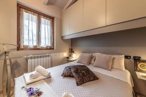 sypialnia z dużym białym łóżkiem z ręcznikami w obiekcie La Dolce Vita - Vista Lago e Piscina w mieście Parzanica