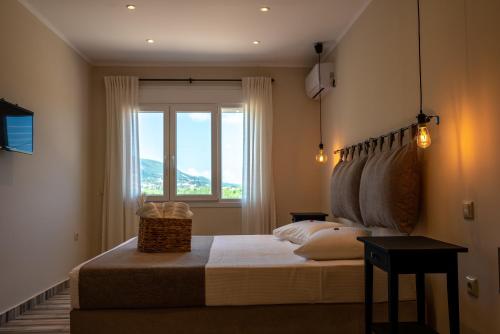 sypialnia z dużym łóżkiem i oknem w obiekcie Casa Di Terra w mieście Pigadhákia