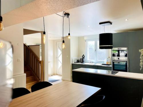 une cuisine avec une table et quelques chaises dans l'établissement Maison Flore, à Besançon