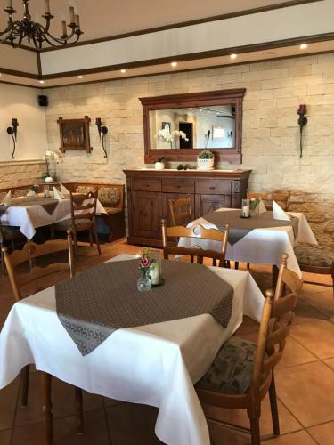 a restaurant with tables and chairs and a mirror at Gasthof zur Post Hotel - Restaurant in Breckerfeld