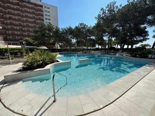 ein großer Pool mit blauem Wasser in einer Stadt in der Unterkunft Residenza Cristallo in Lignano Sabbiadoro