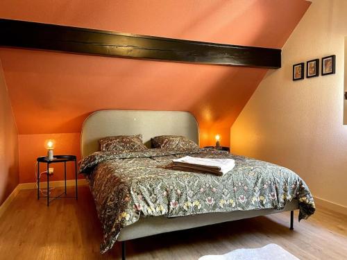 Un dormitorio con una cama con una pared naranja. en Maison Flore, en Besançon