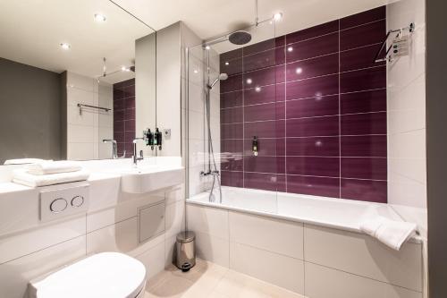uma casa de banho com um chuveiro, um WC e um lavatório. em Premier Inn Leipzig City Oper em Leipzig