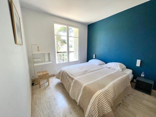 une chambre avec un grand lit avec un mur bleu dans l'établissement CassisCentre-pour famille-piscine plage - 4pers, à Cassis