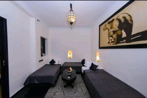 - un salon avec deux lits et une table dans l'établissement Riad Des ours, à Marrakech