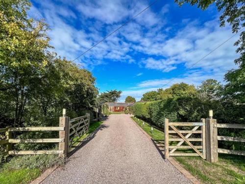 a country road with a fence and a barn at Old Ningwood Station Bed & Breakfast in Shalfleet