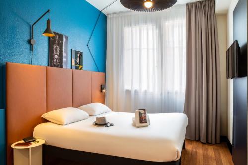 une chambre d'hôtel avec un lit et une fenêtre dans l'établissement ibis Paris Ornano Montmartre Nord 18ème, à Paris