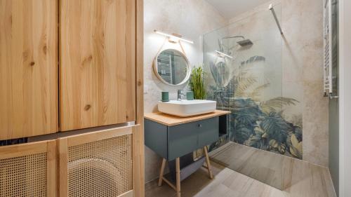 a bathroom with a sink and a mirror at Apartamenty Sun & Snow Sagaris z basenem in Dziwnów