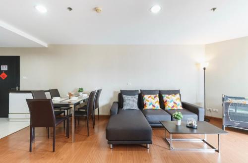 a living room with a couch and a table at Rama9 Luxe Suites in Bangkok