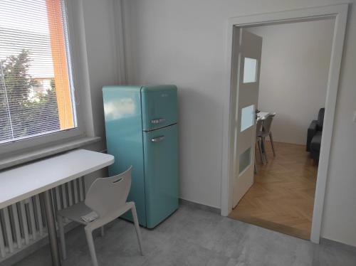 - un réfrigérateur bleu dans une chambre avec une table et une chaise dans l'établissement Dobré místo, à Loučná nad Desnou