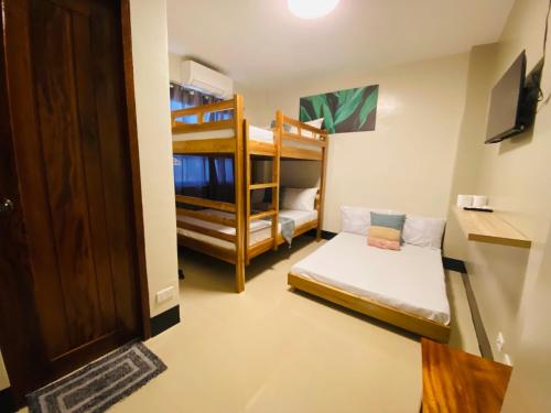 um quarto com 2 beliches e uma porta em Mongki's Pensionhouse em Puerto Princesa