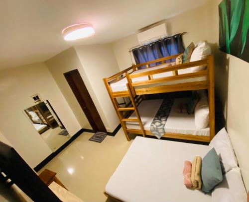 a small room with two bunk beds and a couch at Mongki's Pensionhouse in Puerto Princesa City