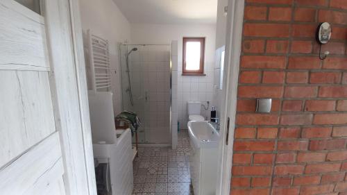 a bathroom with two toilets and a sink and a shower at Apartamenty Pod Lasem in Ostrowo