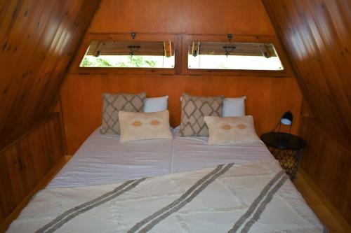- un lit dans une petite chambre avec 2 fenêtres dans l'établissement El Chalet de Ger, cálida casa alpina en la Cerdanya, à Ger