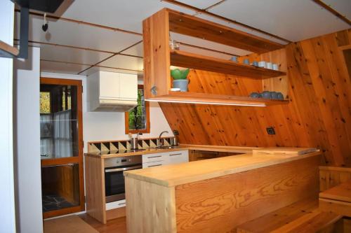 - une cuisine avec des murs en bois et un comptoir en bois dans l'établissement El Chalet de Ger, cálida casa alpina en la Cerdanya, à Ger