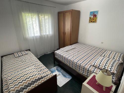a bedroom with two beds and a dresser and a window at Apartments Matija in Sutomore