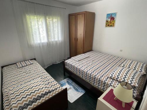 a bedroom with two beds and a dresser and a window at Apartman Matija in Sutomore