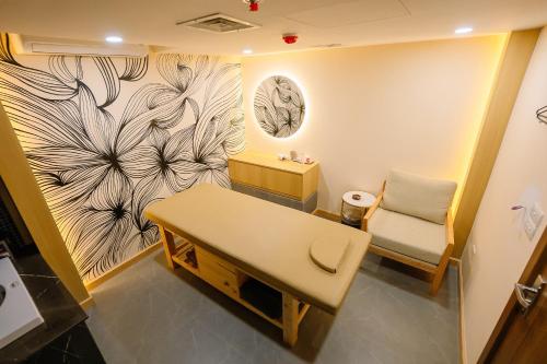 a room with a table and a bench and a wall at Bao Son International Hotel in Hanoi