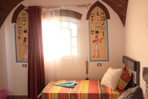 - une chambre avec un lit et une fenêtre dans l'établissement Flower of Life, à Louxor