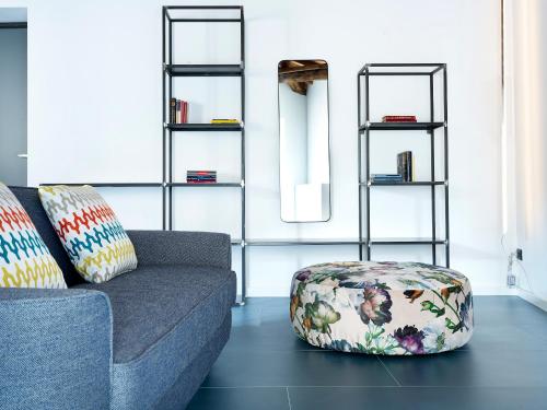 a living room with a couch and a ottoman at SG9 CITY APARTMENTS in Brescia