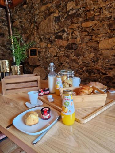 ein Tisch mit Brot und Orangensaft darauf in der Unterkunft Sweet Côa in Sabugal