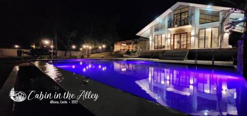 a house with a swimming pool at night at Cabin in the Alley in Alfonso