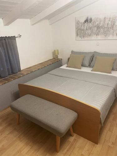 a bedroom with a large bed and a bench at Apartments Papilon in Vrsar