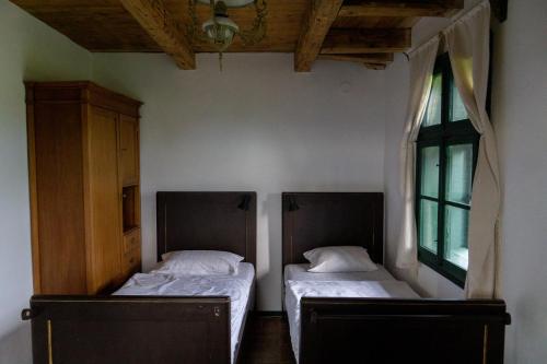 a bedroom with two beds and a window at Hillside View Cottage - Csíksomlyó-panoráma vendégház in Păuleni-Ciuc