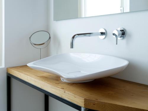 a white sink on a wooden counter in a bathroom at SG9 CITY APARTMENTS in Brescia