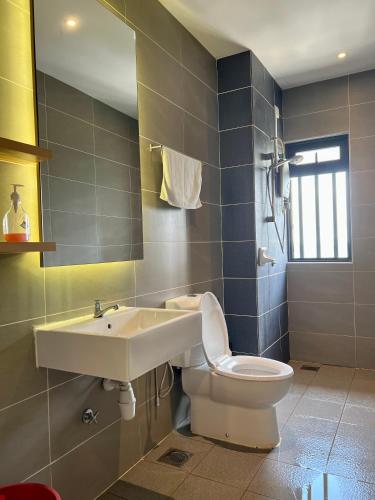 a bathroom with a sink and a toilet at Cozy Hyve Soho Suites in Cyberjaya