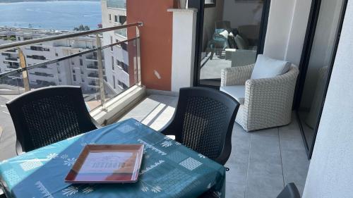 - une table avec un livre sur le balcon dans l'établissement T1 proche aéroport et plage, à Ajaccio