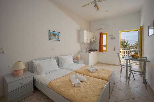 a bedroom with a large bed with towels on it at Cosmi Apts Gouves by Estia in Gouves