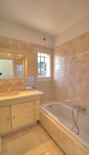 une salle de bain avec une baignoire, un lavabo et un miroir dans l'établissement Villa provençale golfe St Tropez, à Roquebrune-sur Argens