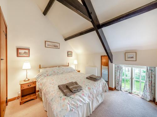 a bedroom with a bed and a large window at Coachmans Cottage - N832 in Wark