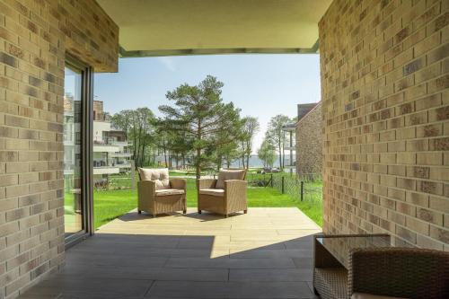 a patio with two chairs and a brick wall at Nautica Resort in Giżycko