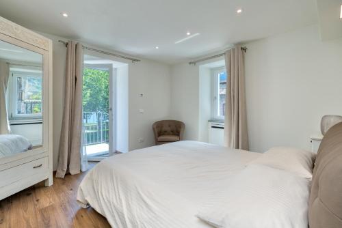 a bedroom with a large white bed and windows at Casa Angelina in Crone