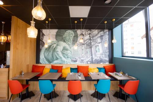 a dining room with tables and colorful chairs at ibis budget Besançon Centre Gare in Besançon