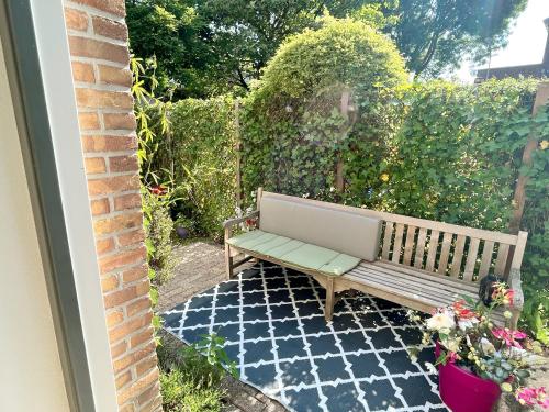 a wooden bench sitting on a tiled patio at The East Wing Bloemendaal in Bloemendaal