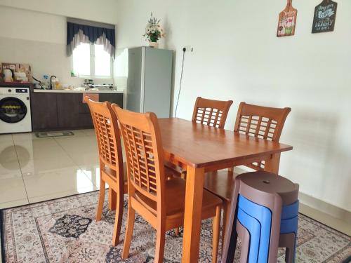 a kitchen with a wooden table with chairs and a refrigerator at KAF Homestay for Musliim only with Pool, 3 Bedroom with Aircond, Smartkey concept, Kids Fun Stay-SlideSwingTrampoline in Perai