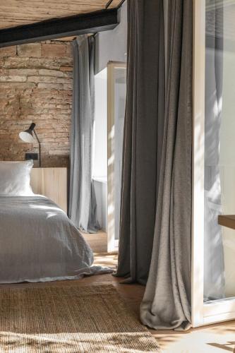 a bedroom with a bed with gray curtains and a mirror at April1550 Boutique Hotel in Ljubljana