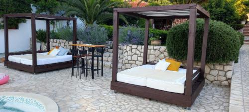 dwa łóżka w altanie na patio w obiekcie Miral Apartments w mieście Supetarska Draga