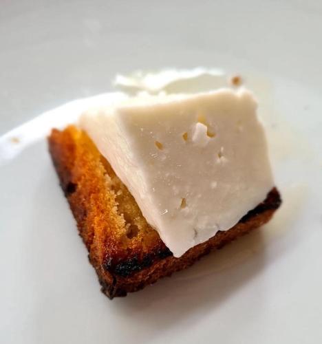 a piece of cake with icing on a white plate at Bar-Restaurant-Hotel-Familja in Klos