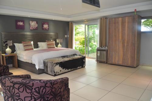 a bedroom with a large bed and a large window at Highveld Splendour Boutique Bed and Breakfast in Ermelo